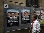 A woman looks at election posters of French far-right Rassemblement National (RN) candidate Sandrine Chadournec (C) in Libourne, southwestern France on July 2, 2024 as part of the French legislative elections. (Photo by Philippe LOPEZ / AFP) (AFP)