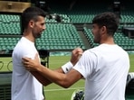 Serbia's Novak Djokovic shakes hands with Spain's Carlos Alcaraz during a practice session on centre court