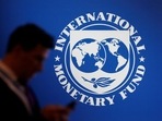 A participant stands near a logo of IMF at the International Monetary Fund - World Bank annual meeting in Bali, Indonesia (Reuters)