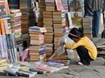 Mumbai, India - April 23, 2024:Young bibliophile checks the books at street vendor's stall on the occasion of "World Book and Copyright Day" at Fort, in Mumbai, India, on Tuesday, April 23, 2024.  (Photo by Anshuman Poyrekar/ Hindustan Times)