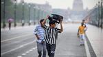 People caught in the rain at Kartavya Path in New Delhi on Saturday. (Sanchit Khanna/HT Photo) People caught in the rain at Kartavya Path in New Delhi on Saturday. (Sanchit Khanna/HT Photo)
