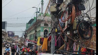 A web of hanging power and telephone cables and exposed junction boxes in Prayagraj city. (HT photo) A web of hanging power and telephone cables and exposed junction boxes in Prayagraj city. (HT photo)