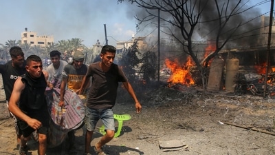 People carry a casualty at the site of what Palestinians say was an Israeli strike at a tent camp in Al-Mawasi area, amid Israel-Hamas conflict, in Khan Younis in the southern Gaza Strip (REUTERS)
