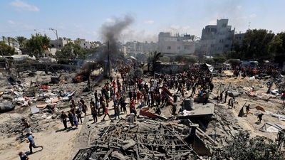 Palestinians gather near damages, following what Palestinians say was an Israeli strike at a tent camp in Al-Mawasi area, amid Israel-Hamas conflict, in Khan Younis in the southern Gaza Strip (REUTERS)