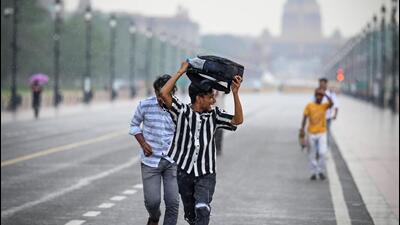 People caught in the rain at Kartavya Path in New Delhi on Saturday. (Sanchit Khanna/HT Photo) People caught in the rain at Kartavya Path in New Delhi on Saturday. (Sanchit Khanna/HT Photo)