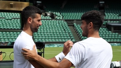 Serbia's Novak Djokovic shakes hands with Spain's Carlos Alcaraz during a practice session on centre court (REUTERS)