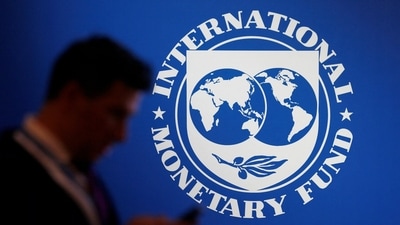 A participant stands near a logo of IMF at the International Monetary Fund - World Bank annual meeting in Bali, Indonesia (Reuters)