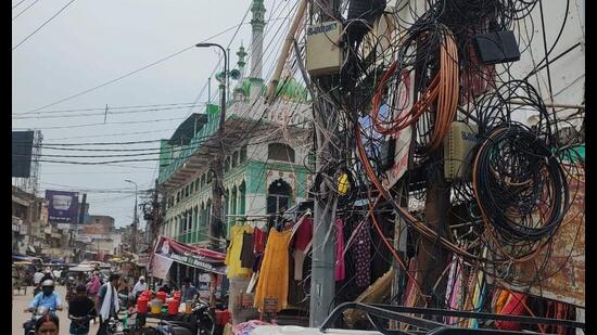A web of hanging power and telephone cables and exposed junction boxes in Prayagraj city. (HT photo)