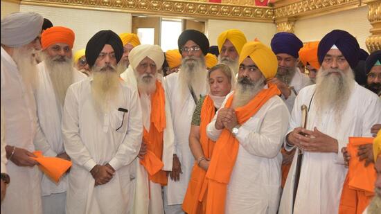 Akal Takht jathedar Giani Raghbir Singh and SGPC president Harjinder Singh Dhami honouring kin of pro-Khalistan leader Gajinder Singh in Amritsar on Saturday. (Sameer Sehgal/HT)