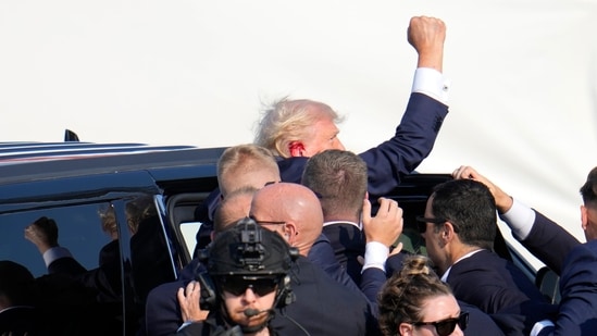 Republican presidential candidate former President Donald Trump pumps his fist as he is helped into a vehicle at a campaign event in Butler, Pa., on Saturday, July 13, 2024. (AP)