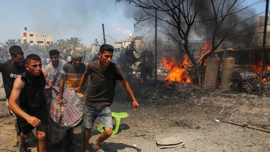 People carry a casualty at the site of what Palestinians say was an Israeli strike at a tent camp in Al-Mawasi area, amid Israel-Hamas conflict, in Khan Younis in the southern Gaza Strip(REUTERS)