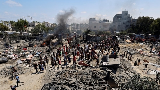 Palestinians gather near damages, following what Palestinians say was an Israeli strike at a tent camp in Al-Mawasi area, amid Israel-Hamas conflict, in Khan Younis in the southern Gaza Strip(REUTERS)
