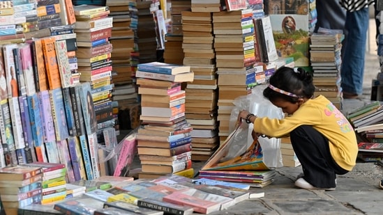 Mumbai, India - April 23, 2024:Young bibliophile checks the books at street vendor's stall on the occasion of "World Book and Copyright Day" at Fort, in Mumbai, India, on Tuesday, April 23, 2024. (Photo by Anshuman Poyrekar/ Hindustan Times)(Hindustan Times)