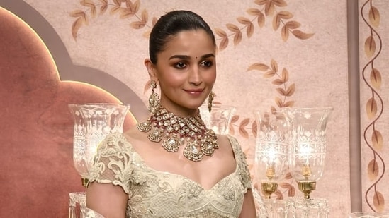 Alia Bhatt looks stunning as ever in a white lehenga with a massive necklace.