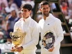 Carlos Alcaraz of Spain holds his trophy as he stands with Novak Djokovic of Serbia after winning the men's singles final at the Wimbledon(AP) Carlos Alcaraz of Spain holds his trophy as he stands with Novak Djokovic of Serbia after winning the men's singles final at the Wimbledon(AP)