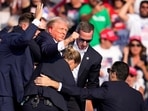 Republican presidential candidate former President Donald Trump is helped off the stage at a campaign event in Butler, Pa., on Saturday, July 13, 2024. (AP Photo/Gene J. Puskar)