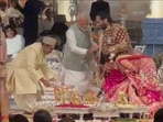 Anant Ambani and Radhika Merchant touching PM Modi's feet. Anant Ambani and Radhika Merchant touching PM Modi's feet.