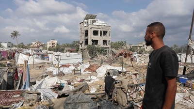 A Palestinian man looks at damaged tents at the site of Israeli bombardment a day earlier on the al-Mawasi displacement camp of Khan Yunis city in the southern Gaza Strip on July 14, 2024, amid the ongoing conflict between Israel and the Palestinian militant Hamas group in Gaza (AFP)