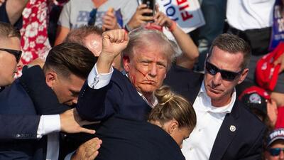 Republican candidate Donald Trump is seen with blood on his face surrounded by secret service agents as he is taken off the stage at a campaign event at Butler Farm Show Inc. in Butler, Pennsylvania, on Saturday. (AFP) Republican candidate Donald Trump is seen with blood on his face surrounded by secret service agents as he is taken off the stage at a campaign event at Butler Farm Show Inc. in Butler, Pennsylvania, on Saturday. (AFP)