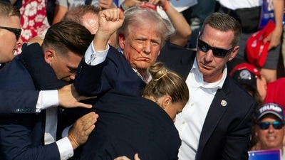 Republican candidate Donald Trump, with blood on his face, was surrounded by Secret Service agents as he was escorted offstage during a campaign event at Butler Farm Show Inc. in Butler, Pennsylvania, on July 13, 2024. He was evacuated after what sounded like gunshots were heard at the Pennsylvania event, according to AFP. (AFP) Republican candidate Donald Trump, with blood on his face, was surrounded by Secret Service agents as he was escorted offstage during a campaign event at Butler Farm Show Inc. in Butler, Pennsylvania, on July 13, 2024. He was evacuated after what sounded like gunshots were heard at the Pennsylvania event, according to AFP. (AFP)