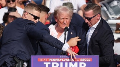 Republican presidential candidate and former U.S. President Donald Trump is assisted by security personnel after gunfire rang out during a campaign rally at the Butler Farm Show in Butler, Pennsylvania, U.S., July 13, 2024. REUTERS/Brendan McDermid