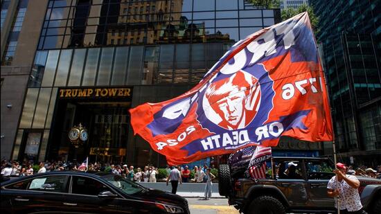 A man carries a flag in support of Republican presidential candidate and former U.S. President Donald Trump, after Trump was injured when shots were fired during a campaign rally held in Butler, Pennsylvania, outside Trump Tower in New York. (REUTERS)