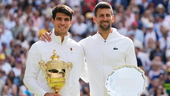 Carlos Alcaraz, left, of Spain holds his trophy after defeating Novak Djokovic, right, of Serbia in the men's singles final at the Wimbledon 2023.(AP)