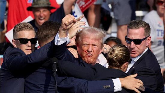 Former US President Donald Trump being assisted by the Secret Service after he was shot at a campaign rally in Pennsylvania on Saturday evening. (REUTERS)