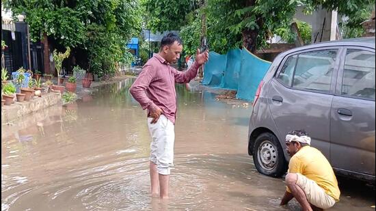 MCG workers clear blocked rainwater harvesting pits in Gurugram Sector 21 on Sunday. (HT Photo)