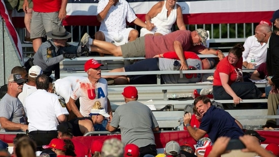 TOPSHOT - Trump supporters are seen covered with blood in the stands after guns were fired atDonald Trump at a campaign event in Butler, Pennsylvania, July 13, 2024. (Photo by Rebecca DROKE / AFP)(AFP)