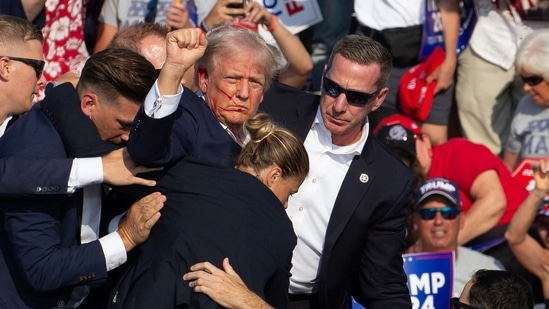 Republican candidate Donald Trump is seen with blood on his face surrounded by secret service agents as he is taken off the stage at a campaign event at Butler Farm Show Inc. in Butler, Pennsylvania, July 13, 2024. Donald Trump was hit in the ear in an apparent assassination attempt by a gunman at a campaign rally on Saturday,(AFP)