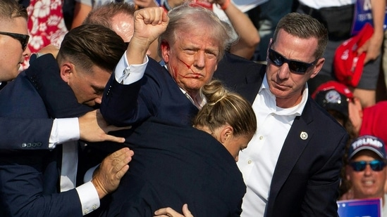 Republican candidate Donald Trump is seen with blood on his face surrounded by Secret Service agents as he is taken off the stage at a campaign event at Butler Farm Show