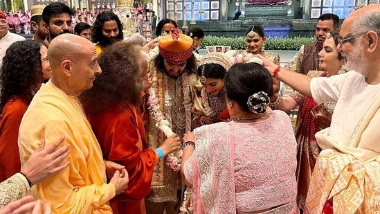 Parmarth Niketan President Swami Chidanand Saraswati gives blessings to the newly wedded couple Anant Ambani and Radhika Merchant during the 'Shubh Aashirwad' ceremony, at Jio World Centre, in Mumbai on Saturday.(ANI)