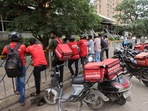 Gig workers wait in line to collect their delivery order outside a mall in Mumbai. (Francis Mascarenhas/Reuters)