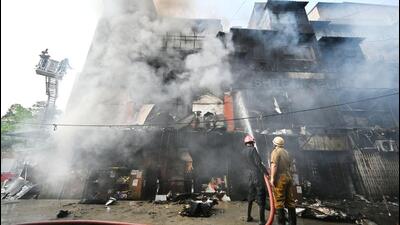 Firefighters douse the blaze on Monday. (Ajay Aggarwal/HT)