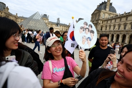 Fans wait for singer and BTS band member Jin to arrive at the Louvre Museum with the Olympic flame. (REUTERS)