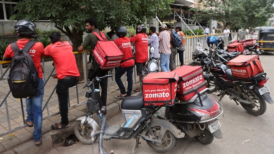 Gig workers wait in line to collect their delivery order outside a mall in Mumbai. (Francis Mascarenhas/Reuters)