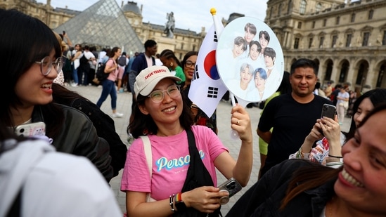 Fans wait for singer and BTS band member Jin to arrive at the Louvre Museum with the Olympic flame. (REUTERS)