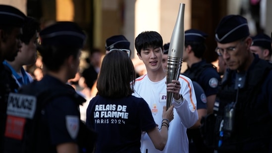 Jin, the oldest member of K-pop supergroup BTS, is given the Olympic torch, in Paris. (AP)