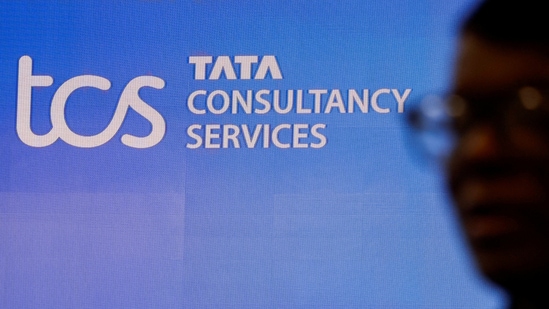 A man walks past a logo of Tata Consultancy Services (TCS) before a press conference.(Reuters)