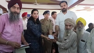 DC Sakshi Sawhney and MLA Jagtar Singh Dayalpura handing over the documents to the beneficiaries on Tuesday. (HT Photo)