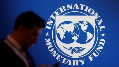 A participant stands near a logo of IMF at the International Monetary Fund - World Bank annual meeting. (Reuters)