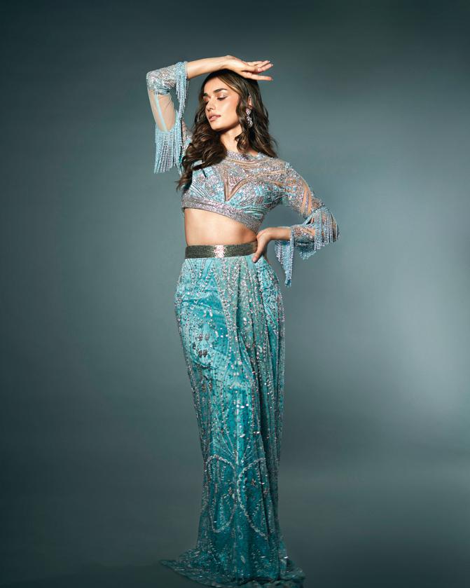 Outfit: Suneet Varma Jewellery: Alok Lodha Jewels Manushi Chhillar is beauty personified in this ice-blue draped skirt with delicate beads and crystal work in art deco motifs paired with a sheer, embellished blouse with tasselled sleeves. Her hair has been styled in middle-parted soft waves and this look is ideal for your cocktail function as it’s a far cry from the quintessential shimmery dresses or gown that bride-to-bes usually choose for their cocktail nights. The actor spruces up the look with further with diamond earrings from Alok Lodha Jewels. Designer Suneet Varma will be partaking in FDCI Manifest Wedding Weekend on Aug 3-4, at Taj Palace Hotel, New Delhi.