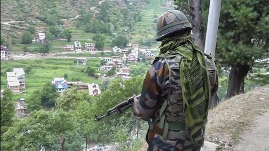 A security official stands guard near the site of the recent encounter with terrorists at Desa village in Doda district on Wednesday. (PTI Photo)