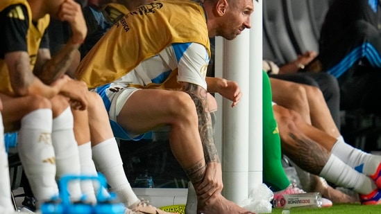 Argentina's Lionel Messi touches his ankle sitting at the bench during a Copa America soccer final match against Colombia in Miami Gardens(AP)