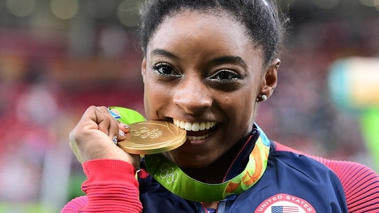 US gymnast Simone Biles celebrates with her gold medal after the women's individual all-around final of the Artistic Gymnastics at the Olympic Arena during the Rio 2016 Olympic Games.(AFP)