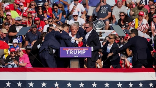Republican presidential candidate and former U.S. President Donald Trump is assisted by U.S. Secret Service personnel after he was shot in the right ear during a campaign rally at the Butler Farm Show in Butler, Pennsylvania, U.S., July 13, 2024. REUTERS/Brendan McDermi(REUTERS)
