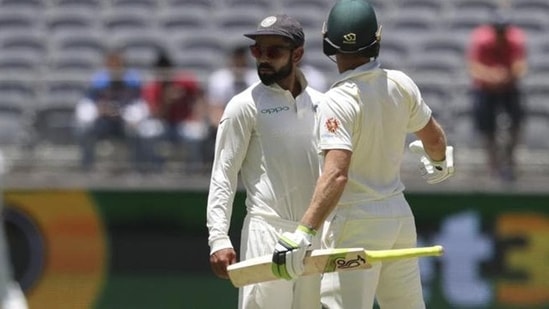 India's Virat Kohli, centre, looks to the umpire after he and opposing captain, Australia's Tim Paine came face to face in Perth.(AP)