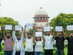 Students display placards in the precinct of the Supreme Court during a hearing on the NEET paper leak case, in New Delhi. 