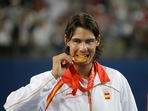 Rafael Nadal bites his gold medal for the photographers after beating Fernando Gonzalez of Chile during their Gold medal singles tennis at the Beijing 2008 Olympics. Rafael Nadal bites his gold medal for the photographers after beating Fernando Gonzalez of Chile during their Gold medal singles tennis at the Beijing 2008 Olympics.